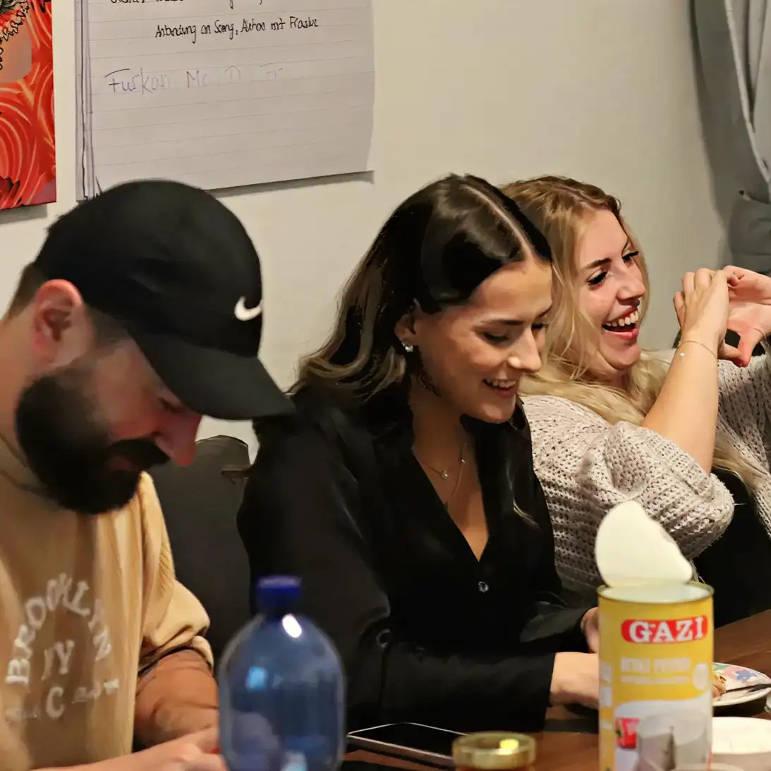 Teamarbeit von 3 Personen, mit sichtbarer Freude bei der Zusammenarbeit 